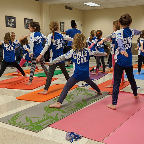 Elementary age girls doing yoga as part of the Girls Can program