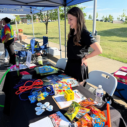 Karolina working at a table with giveaway items