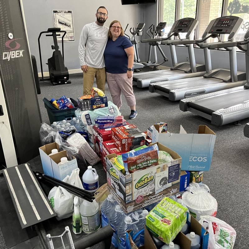 Students behind a stack of goods purchases to assist flood victims