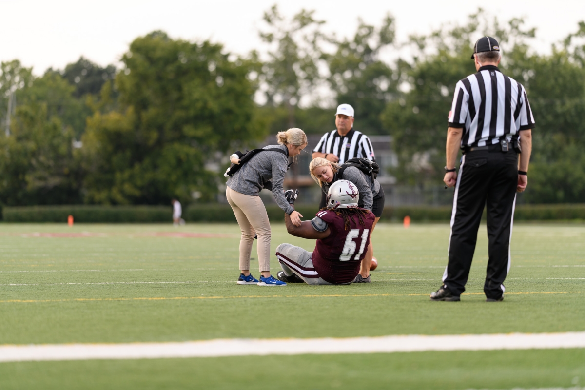 Athletic Trainer working with football player